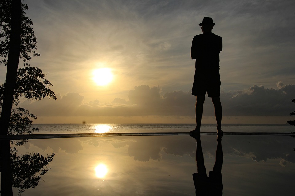 Silhouette of Man overlooking sea into Sunset